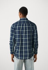 Marineblauwe en groene geruite lange mouwen shirt met een button-down kraag en een afgeronde zoom, gemaakt van katoen, met een ontspannen pasvorm en knopenmanchetten.