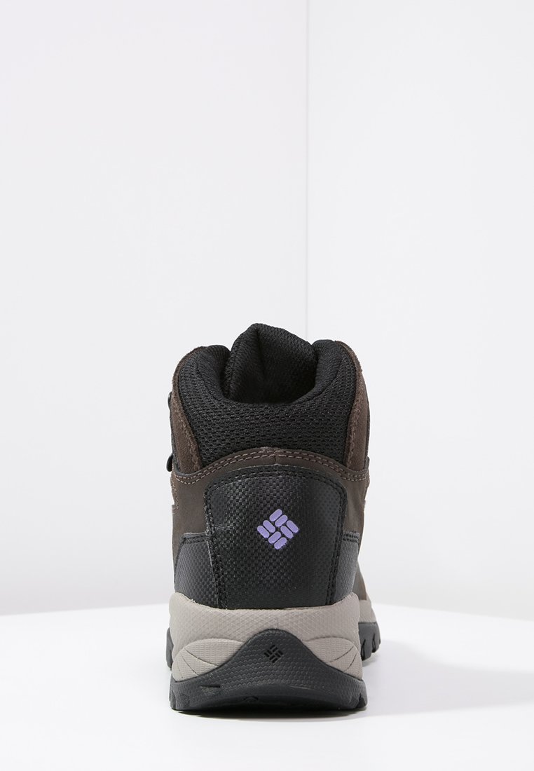 Scarponcino da trekking marrone e nero con tomaia in rete e pelle, colletto imbottito, suola grigia e dettaglio del logo viola sul tallone.