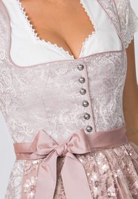 Rosa gemustertes Kleid mit silbernen Knöpfen, satinierter Taille und einer Schleife. Verfügt über Spitzenverzierungen an den Ärmeln und einen dekorativen Rock.