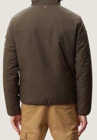 Olivengrøn polstret jakke med høj krave, synlige sømme og logoaccents på ærmerne. Struktureret stof med en glat overflade.