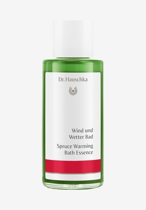 Green plastic bottle of Spruce Warming Bath Essence with a white label, red accent at the base, and black text. Screw-on white cap.