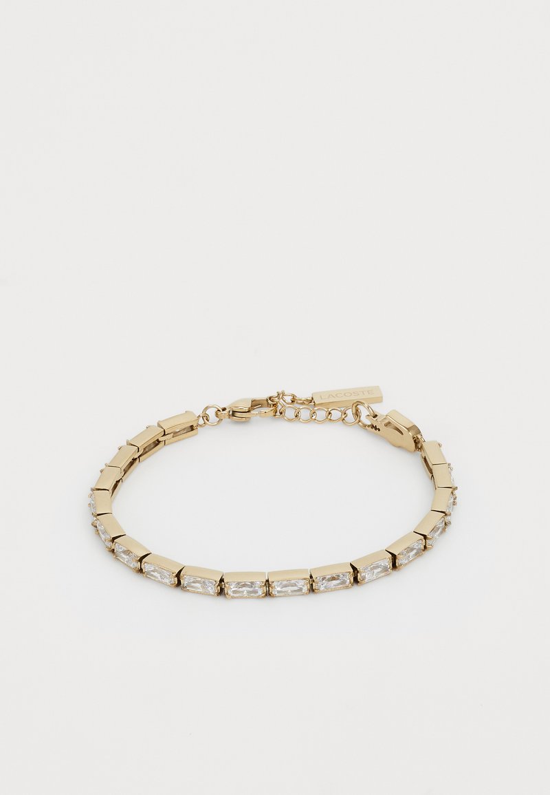 Gold bracelet with rectangular links and clear rectangular stones. Features a clasp and small extendable chain with a tag.