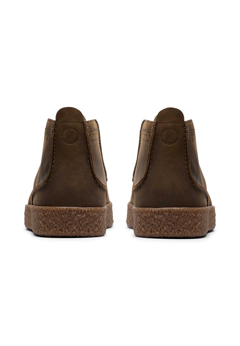 Braune Leder-Stiefeletten mit einer strukturierten braunen Sohle, die übersteppte Details und ein auf die Ferse geprägtes Logo aufweisen.