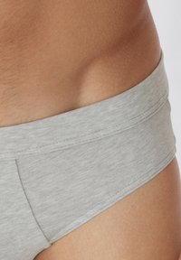 Szare bawełniane bokserki z szerokim elastycznym pasem, charakteryzujące się gładką teksturą i prostym przeszyciem wzdłuż szwów.