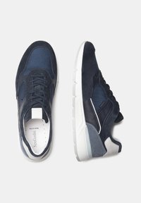 Sneakers blu navy con pannelli in rete e dettagli in suede. Presentano una suola intermedia bianca, lacci texture e un dettaglio del logo sulla linguetta.