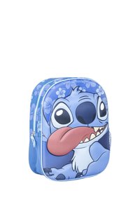 Blauwe rugzak met een cartoonfiguur met grote ogen en een opvallende tong, versierd met bloemenpatronen en een ritssluiting.