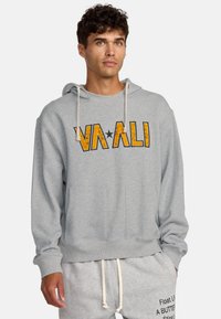 Szary hoodie z przednią kieszenią, z wyraźnym żółtym i czarnym napisem "VAALI". Posiada regulowany kaptur z sznurkiem oraz ściągacze na rękawach.