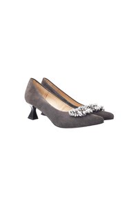 Zapatos de tacón alto de ante gris con punta afilada y un tacón geométrico negro, que cuentan con un adorno decorativo de strass en la parte frontal.
