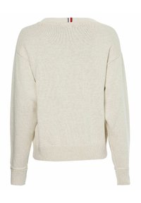 Jasny beżowy sweter o dzianinowej fakturze, luźnym kroju, opadających ramionach, ściągaczach u mankietów i u dołu. Posiada cienki czerwony i niebieski pasek na plecach przy szyi.