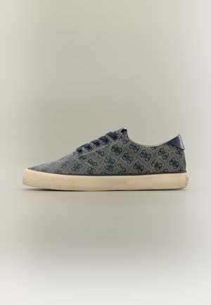 Flacher Sneaker in Marineblau mit ineinandergreifenden dunklen Logos, marineblauen Schnürsenkeln und einer beigen Gummisohle mit strukturiertem Zehenschutz.