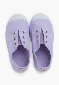 Lilac canvas shoes with white rubber toe caps and multiple metal eyelets for laces. Features a fabric tag on the heel.