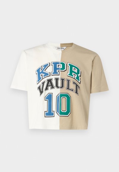 Izgriezta T-kreklu ar dalītu dizainu, viena puse balta, otra puse bēša. Iekļauj drosmīgus attēlus: "KPR VAULT" un "10" zilā un zaļā krāsā. Ražots no kokvilnas materiāla.