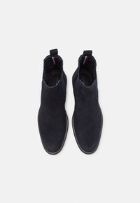 Marineblauwe suède enkelboots met elastische zijpanelen en trekflappen. Heeft een gladde textuur, een ronde neus en een contrasterende binnenvoering.