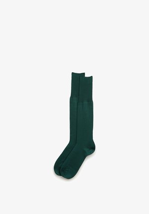 Par de calcetines largos verde oscuro con puño acanalado, planos sobre fondo blanco.