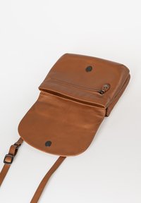 Bruine leren schoudertas met een gladde textuur, een klep afsluiting en een voorvak met rits. Beschikt over verstelbare banden en zwarte hardware accenten.