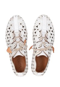 Witte leren schoenen met ingewikkelde bloemige uitsparingen, beige veters en een bruine binnenvoering. Beschikt over een platte zool en een achtertab voor gemakkelijk aan- en uittrekken.