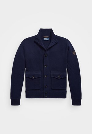 Navy blauwe cardigan van breiwerk, met een sjaalkraag, knoopsluiting, twee voorzakken en een schouderpatchdetail.