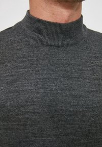 Dunkelgrauer Rollkragenpullover mit geripptem Kragen und einem weichen, strukturierten Strick. Der Stoff wirkt glatt mit subtilen Variationen.