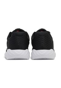 Svarta träningsskor med en texturerad meshovandel, som har en dämpad vit sula. Bakifrån syns en slät, rundad h äl.