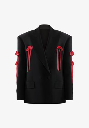 Mustast ülikonnajakk topeltteibiga, struktuursete õlgadega, kaunistatud punaste paelavõruga, mis on seotud mööda mõlemat varrukat.