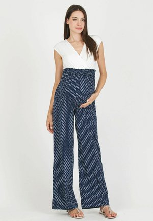 Salopette a pois navy con top avvolgente bianco e vita arricciata. Presenta un design a gamba larga e una vestibilità comoda. Tessuto leggero.