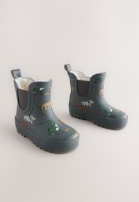 Bottes de pluie en caoutchouc gris avec une surface texturée, ornées de motifs colorés de dinosaures, panneaux élastiques gris et poignées pour un enfilage facile.