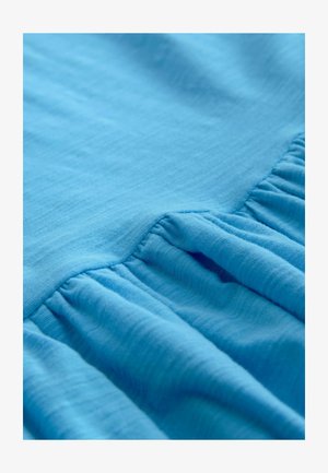 Light blue fabric with a soft, textured finish, featuring gathered ruffle accents along one edge for added detail.