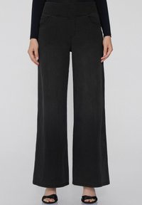 Pantalones de mezclilla negros de pierna ancha con una textura suave, que cuentan con bolsillos frontales y una cinturilla elástica alta para mayor comodidad y estilo.