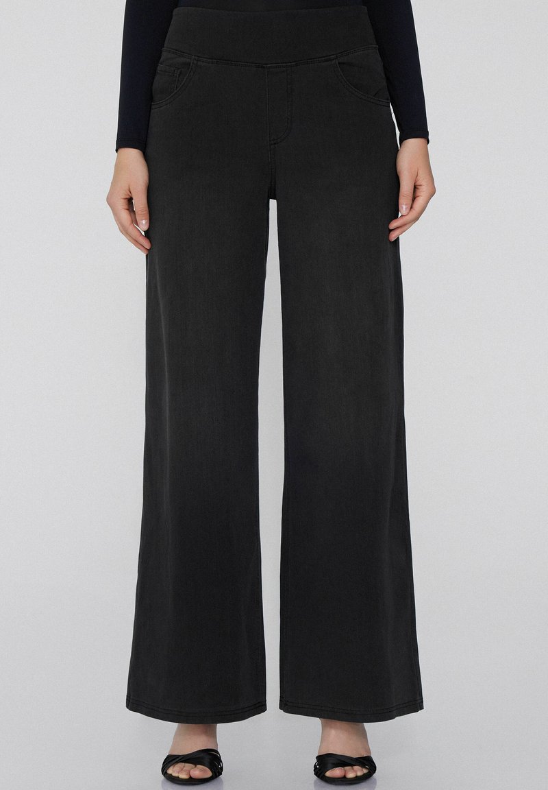 Pantalones de mezclilla negros de pierna ancha con una textura suave, que cuentan con bolsillos frontales y una cinturilla elástica alta para mayor comodidad y estilo.