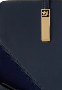 Granatowa skórzana torebka z geometrycznym wzorem, o gładkiej teksturze, wykończona zapięciem w złotym kolorze.