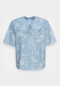 Blusa de manga curta azul clara com um colarinho grande e franjado, decorada com ilustrações botânicas e animais em branco. Tecido suave.