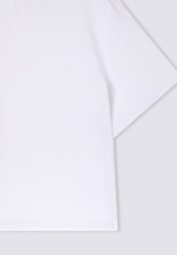 T-shirt bianco a maniche corte realizzato in tessuto testurizzato, caratterizzato da una vestibilità morbida e un design minimalista e fluido, privo di motivi o dettagli.