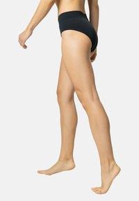 Sous-vêtements noirs taille haute en matériau extensible, présentant une texture lisse et un design minimaliste, sans motifs ni matériel visible.