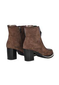 Botines de ante marrón con punta redondeada, tacón grueso negro, cremallera lateral y acentos metálicos en el tacón y el cuello.