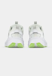 Weiße Sportschuhe mit einer strukturierten Oberseite, grünen Akzenten an den Sohlen und Zuglaschen an der Ferse. Leichtes und gedämpftes Design.