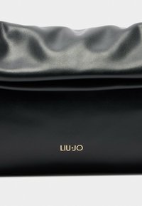 Zwarte zachte leren clutch met een geraffineerde bovenkant en het gouden LIU·JO-logo centraal op de voorkant, tegen een witte achtergrond.