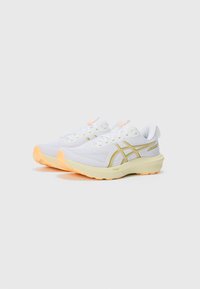 White athletic shoes with yellow accents, mesh upper for breathability, and textured rubber outsole in orange. Features a padded collar and laces.