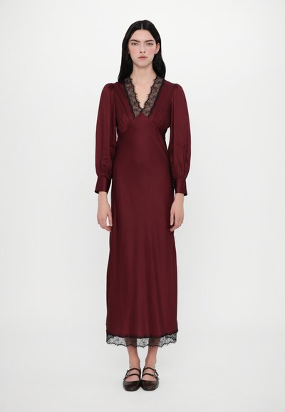 Robe bordeaux à manches longues avec dentelle le long de l'encolure et de l'ourlet, arborant un corsage ajusté et une jupe fluide. Texture de tissu lisse.