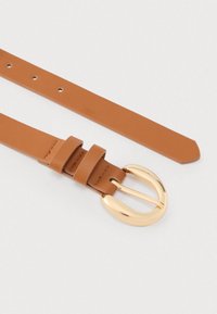 Curea maro din piele cu o cataramă metalică aurie. Curea are două bucle mici din piele și găuri pentru ajustare. Textură netedă.