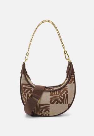 Half-moon shaped beige and brown fabric handbag with repeating "SM" pattern, gold chain handle, additional brown adjustable strap, and Steve Madden logo.