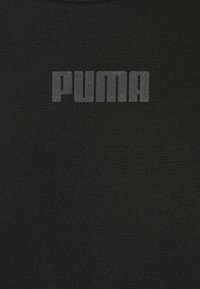 Tissu texturé foncé avec le mot « PUMA » imprimé en lettres capitales grises en gras, centré sur la surface.