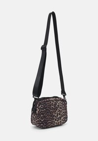 Bolso bandolera de estampado de leopardo con una tela duradera, correa negra ajustable, forma rectangular y cierre con cremallera. Detalle de superficie texturizada.