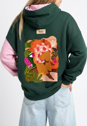 Zielona bluza z kapturem z różowymi rękawami, z kolorową ilustracją na plecach. Wzór obejmuje motywy kwiatowe i roślinne, z metką.