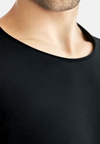 Svart kortärmad tröja, slät textur, bred halsringning, åtsittande design. Tyger är lätta och mjuka mot huden.