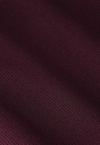 Tissu bourgogne profond avec une texture à fines lignes verticales et de subtils plis diagonaux créant de douces ombres.