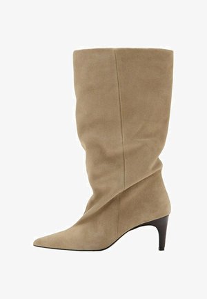 Stivale da donna in camoscio beige fino a metà polpaccio con punta affilata e tacco basso a gattino nero.