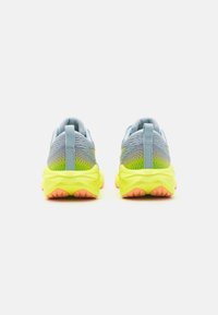 Scarpe da corsa con una parte superiore blu chiaro, motivi testurizzati, intersuola gialla neon e suola arancione. Presenta un'anello di trazione sul tallone.