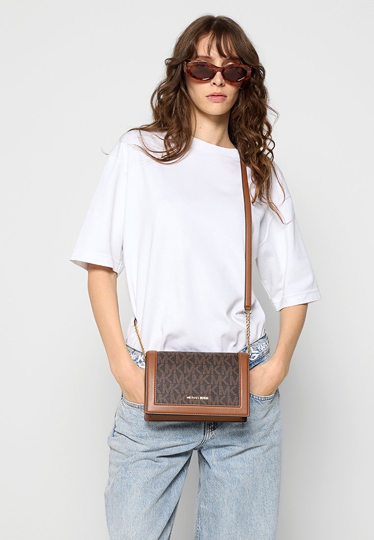 Braune Umhängetasche mit geprägt Logo und Kettenriemen, die eine strukturierte rechteckige Form und eine strukturierte Vorderseite aufweist.