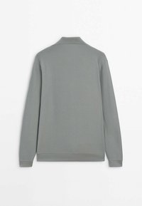 Szara koszulka polo z długim rękawem o prążkowanej fakturze, z kołnierzykiem i dopasowanymi mankietami. Widok z tyłu ukazuje gładki, minimalistyczny design.