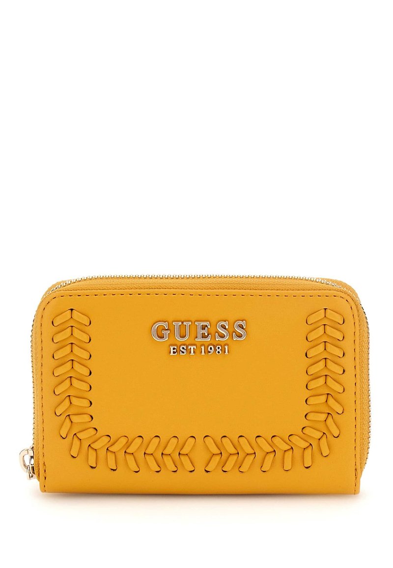 Yellow leather wallet with embossed stitching detail and silver hardware. Features "GUESS EST 1981" logo prominently on the front. Zipper closure.